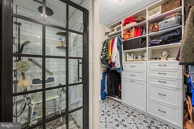 a view of walk in closet with clothes and shoes