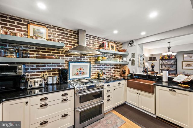 a kitchen with stainless steel appliances granite countertop a stove and cabinets