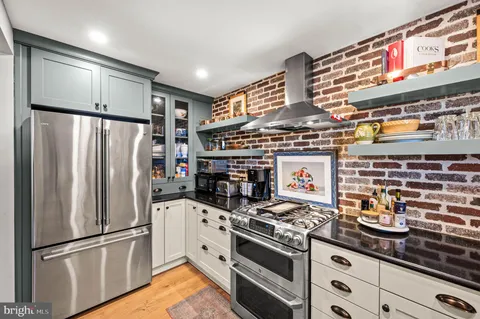 a kitchen with stainless steel appliances granite countertop a refrigerator and a stove