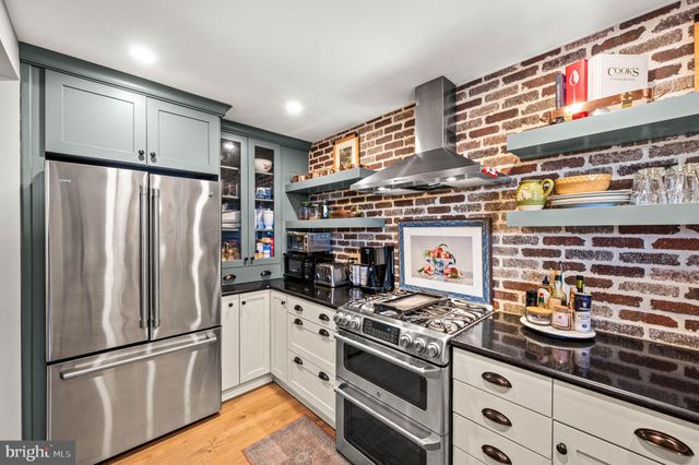 a kitchen with stainless steel appliances granite countertop a refrigerator and a stove