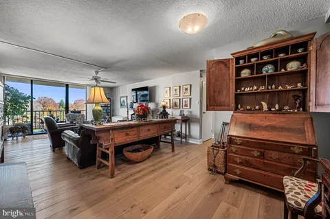 a living room with furniture cabinets and wooden floor