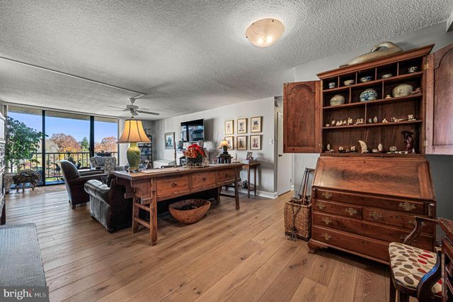 a living room with furniture cabinets and wooden floor