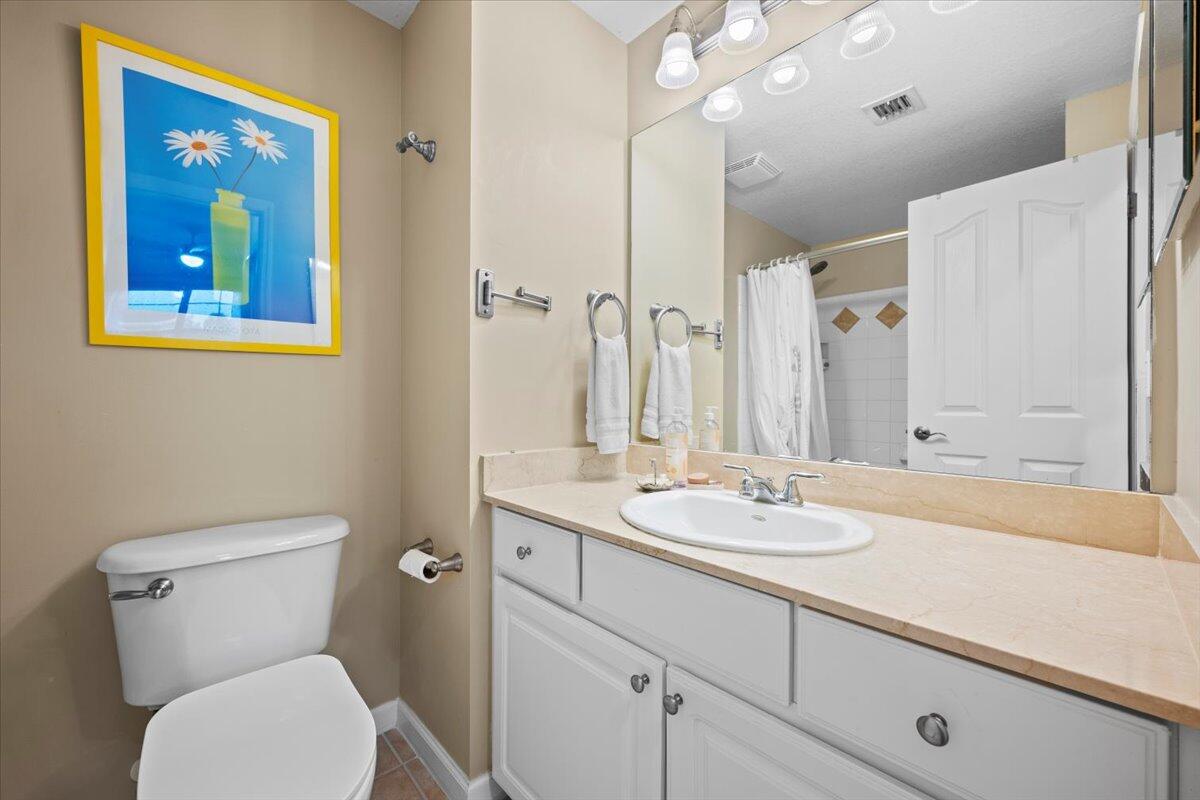 155 Galicia Way, Unit 202 Jupiter, FL 33458 - Photo 18 of 30 a bathroom with a granite countertop sink mirror vanity and toilet