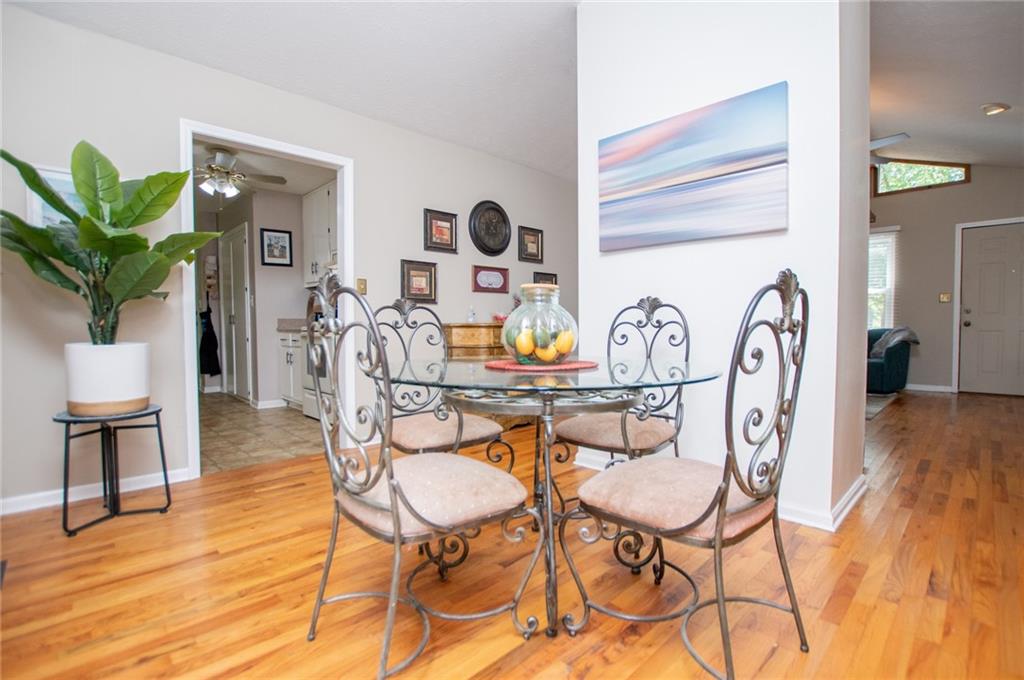 1385 Lakeview Parkway Villa Rica, GA 30180 - Photo 26 of 71 a dining room with furniture a rug a potted plant and wooden floor