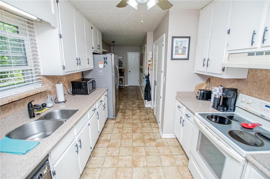 1385 Lakeview Parkway Villa Rica, GA 30180 - Photo 30 of 71 a kitchen with stainless steel appliances granite countertop a sink stove and cabinets