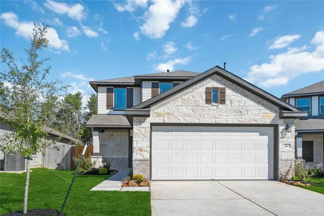 a front view of a house with a yard and garage