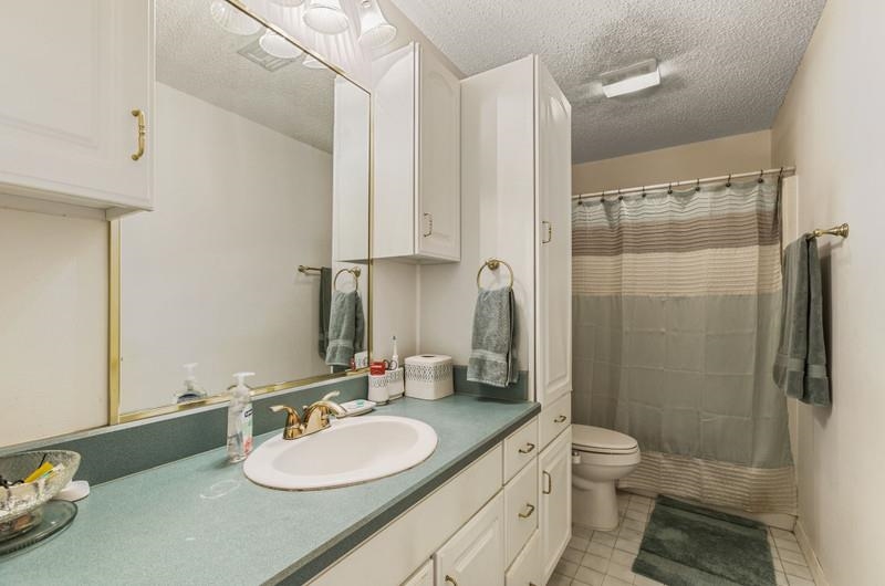 173 Stokes Landing Road St. Augustine, FL 32095 - Photo 27 of 71 a bathroom with a granite countertop sink toilet a mirror and shower