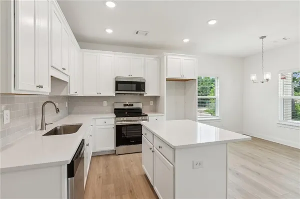 a kitchen with granite countertop white cabinets and white appliances