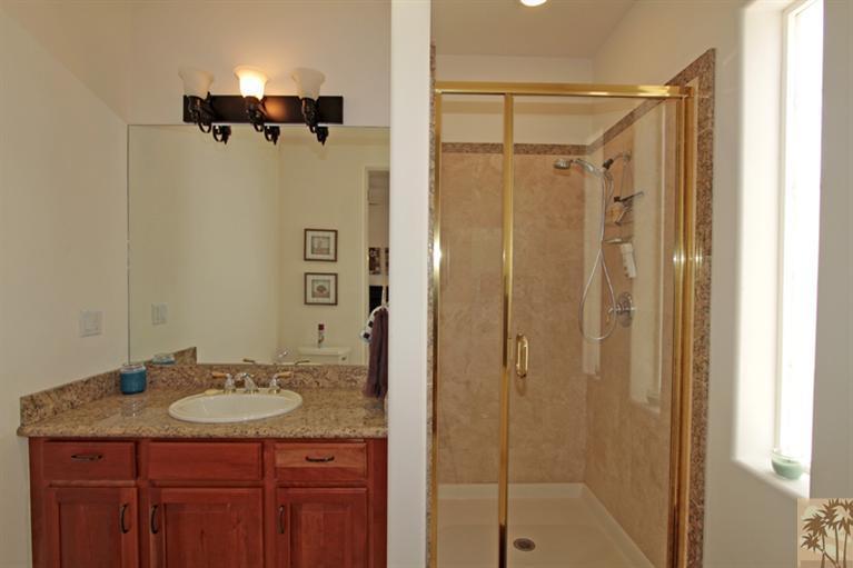 79175 Bermuda Dunes Drive Bermuda Dunes, CA 92203 - Photo 15 of 21 a bathroom with a granite countertop sink shower mirror and a mirror