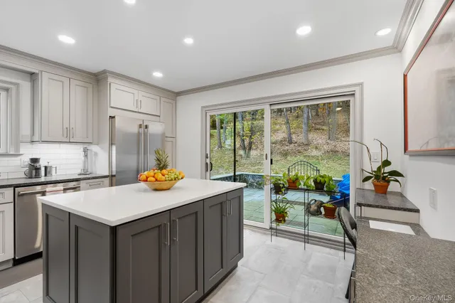 a kitchen that has a sink and chairs in it