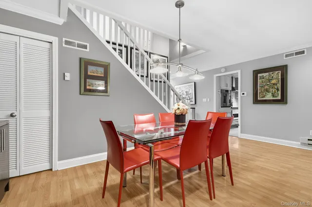 a dining room with furniture entryway and wooden floor