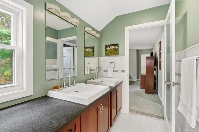 a en suite bathroom with a granite countertop sink and a mirror