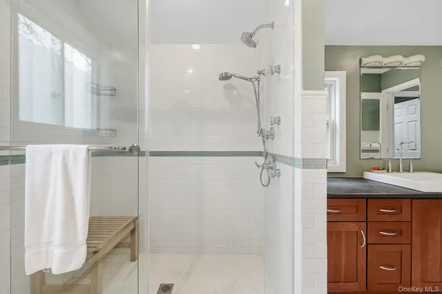 a bathroom with a granite countertop shower sink and mirror