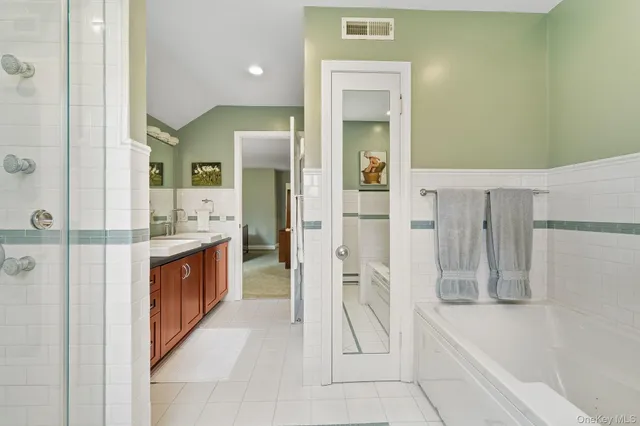 a bathroom with a tub sink and mirror