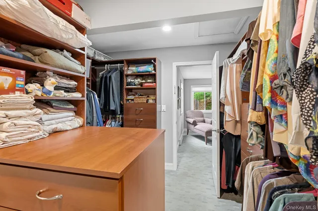 a view of walk in closet with clothes and shoes