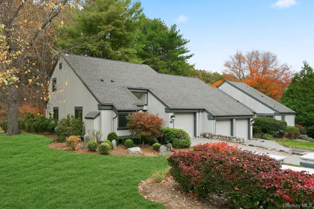 a view of a house with a big yard plants and large trees