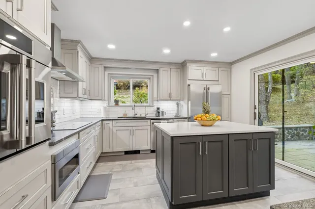 a kitchen with stainless steel appliances granite countertop a sink a stove and a refrigerator