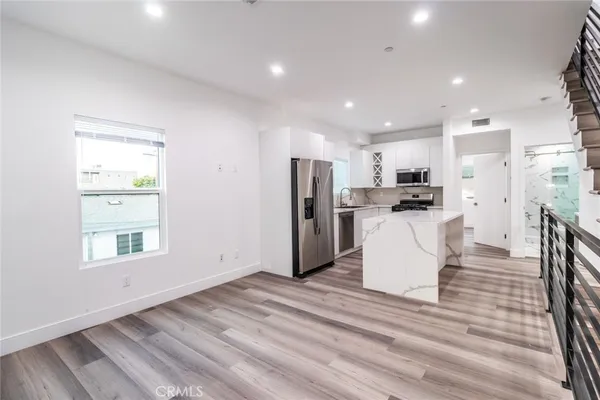 a kitchen with cabinets stainless steel appliances a sink and a window