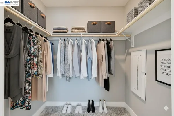a view of walk in closet with clothes and shoes
