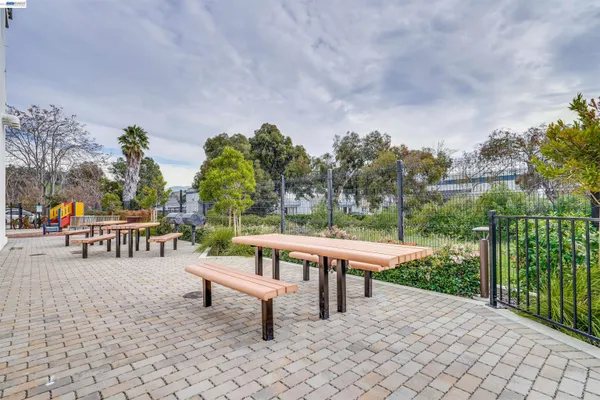 a roof deck with table and chairs couches with wooden fence