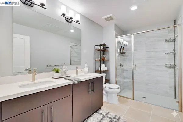 a bathroom with a double vanity sink toilet and shower