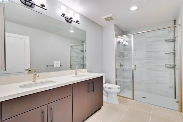 a bathroom with a double vanity sink toilet and shower