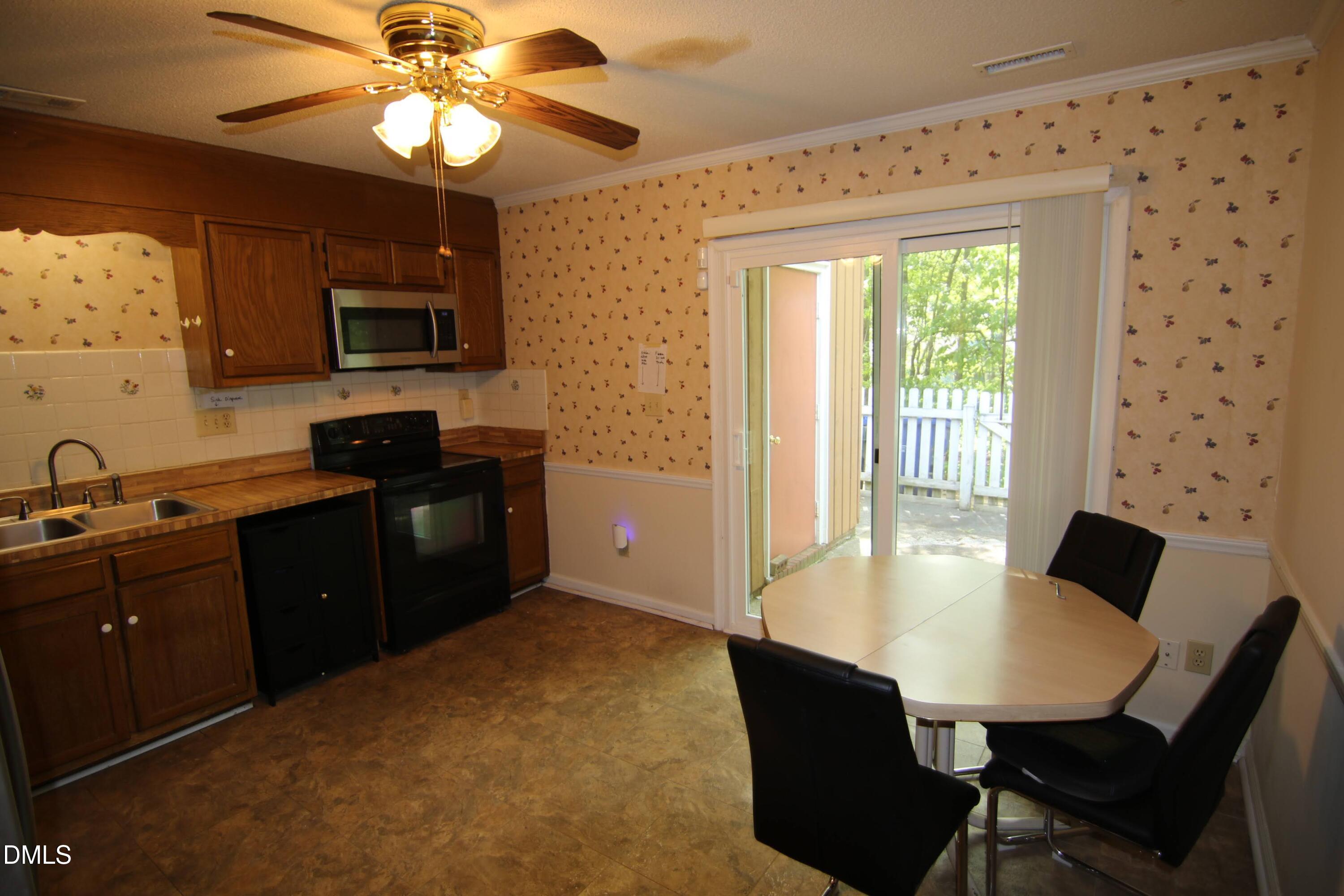 84 Candytuff Lane Durham, NC 27713 - Photo 19 of 23 a kitchen with a table chairs refrigerator and microwave