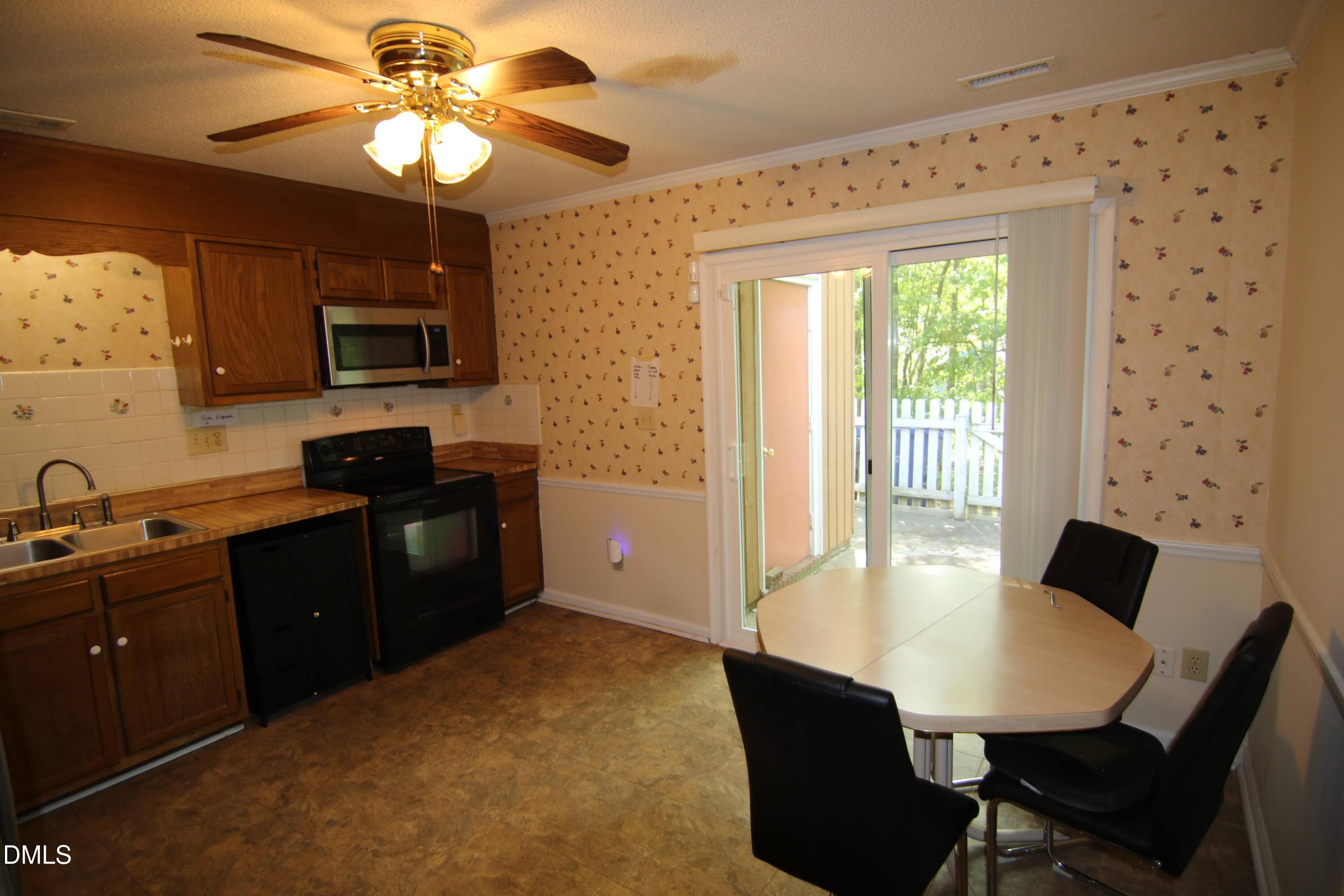 84 Candytuff Lane Durham, NC 27713 - Photo 8 of 23 a kitchen with a table chairs refrigerator and microwave