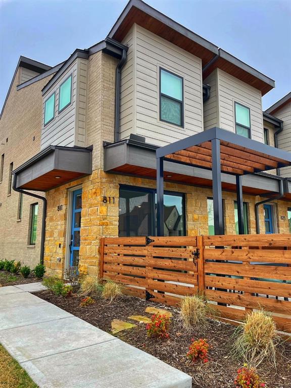 View of front facade featuring stone siding and fence