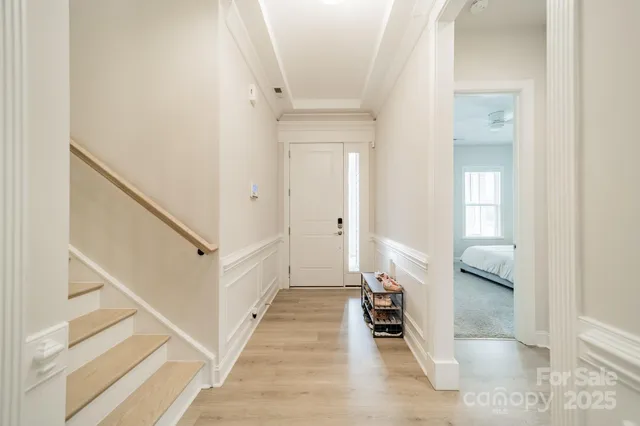 a view of a hallway with white walls and stairs