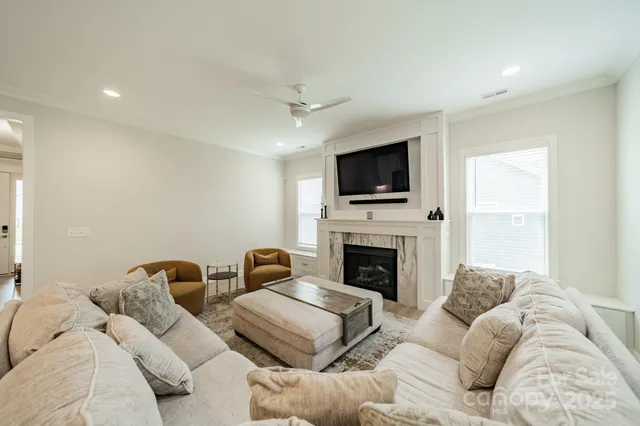 a living room with furniture a flat screen tv and a fireplace