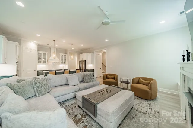 a living room with furniture a rug and kitchen view