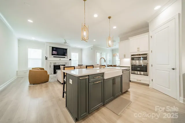 a large kitchen with kitchen island a sink a counter space stainless steel appliances and cabinets
