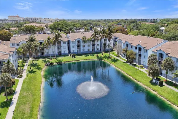 an aerial view of residential houses with outdoor space and lake view