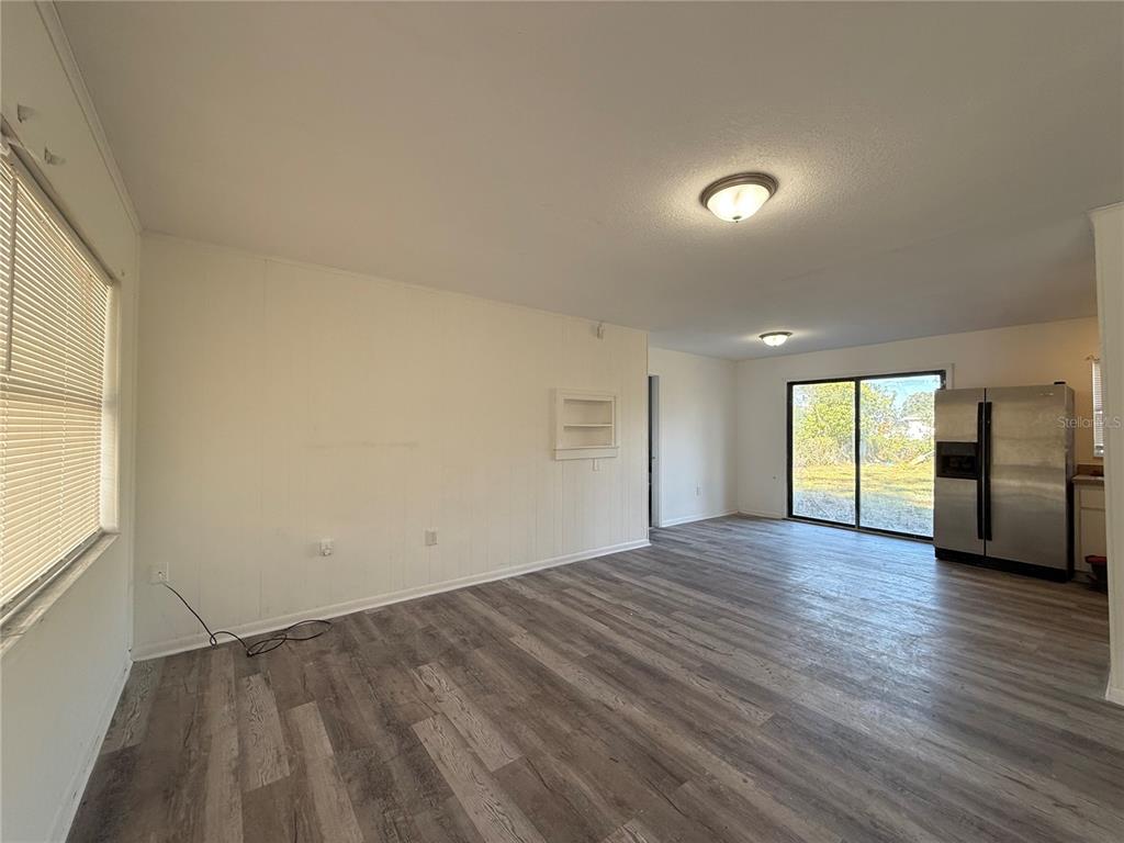 2213 Northwest 24th Road Ocala, FL 34475 - Photo 4 of 6 an empty room with wooden floor and windows