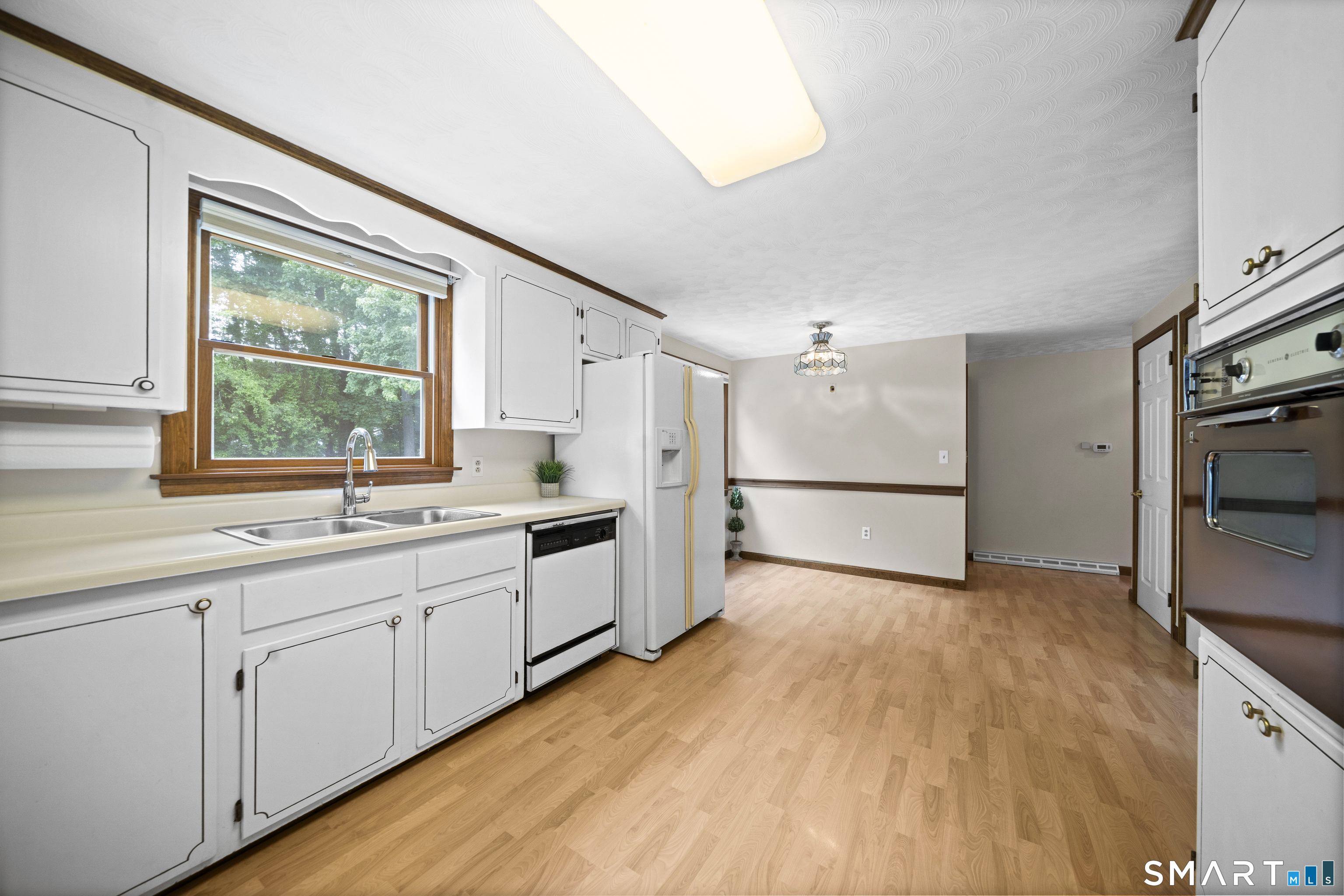 6 Cartier Road Enfield, CT 06082 - Photo 9 of 40 a kitchen with white cabinets and wooden floor