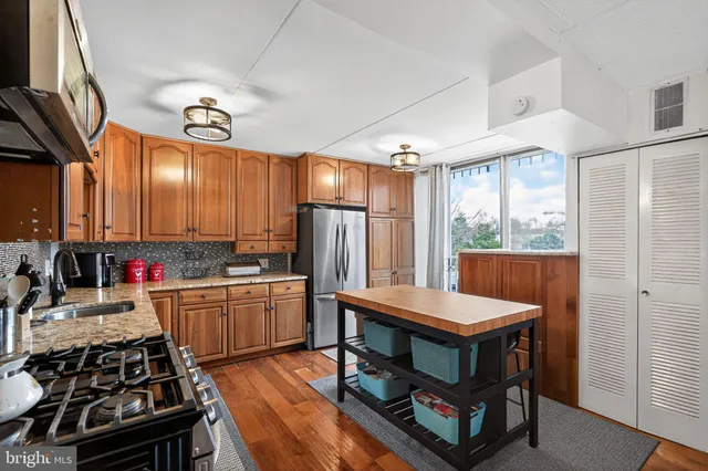 a kitchen with stainless steel appliances a stove a refrigerator and a kitchen island