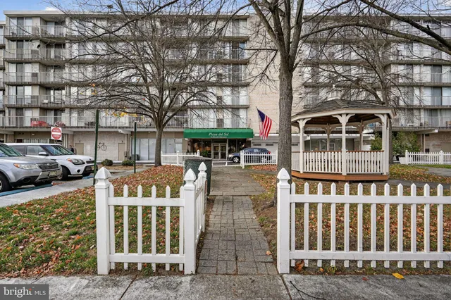 a front view of a building with large trees
