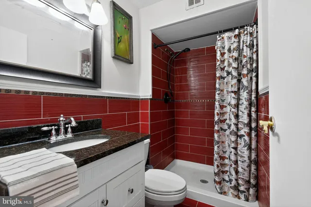 a bathroom with a granite countertop sink toilet and shower