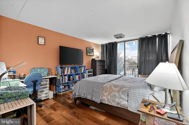 a bedroom with a bed bookshelf and a flat screen tv