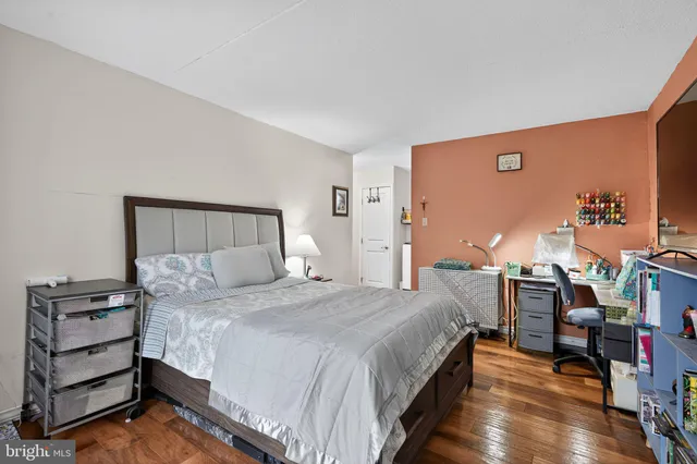 a bedroom with a bed and a flat tv screen on the dresser