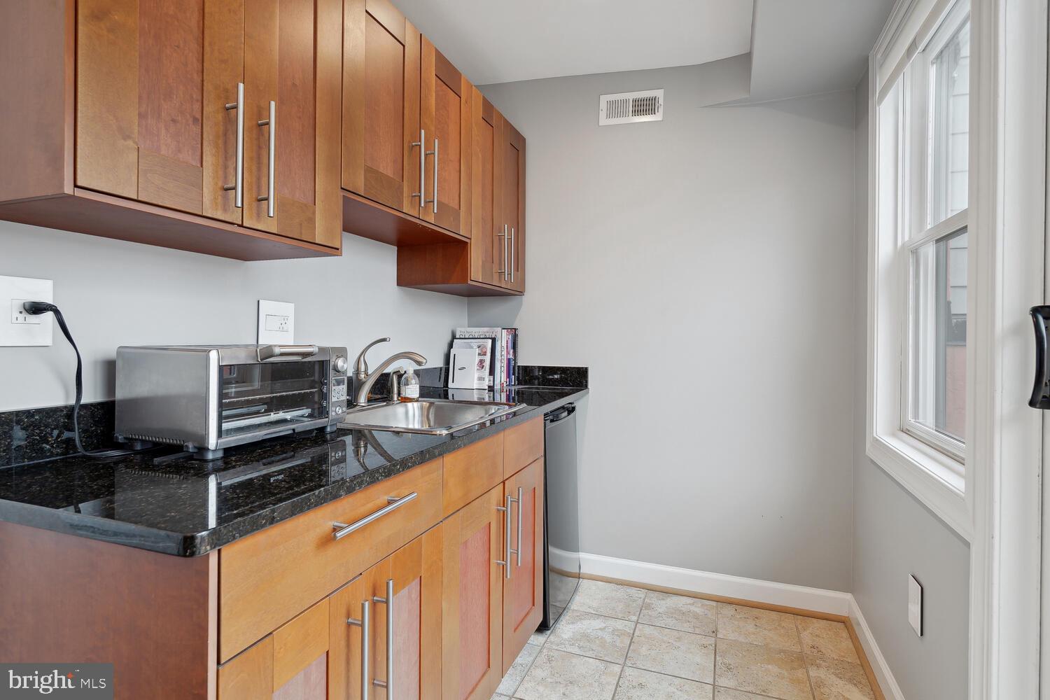 2242 Ontario Road Northwest, Unit 3 Washington, DC 20009 - Photo 18 of 20 a kitchen with stainless steel appliances granite countertop a sink stove and cabinets