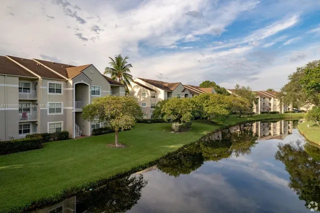 a view of a house with a yard next to a lake