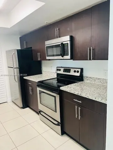 a kitchen with stainless steel appliances granite countertop a stove microwave and sink