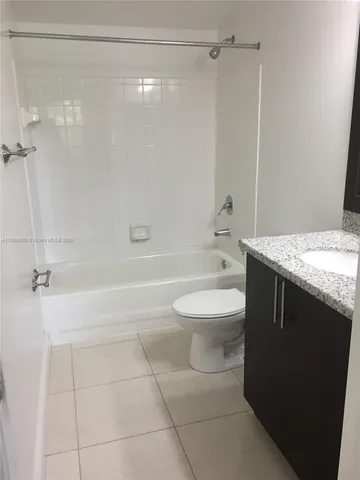 a bathroom with a granite countertop sink a toilet and shower