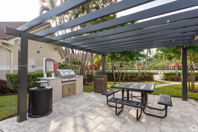 a patio with a table and chairs and potted plants
