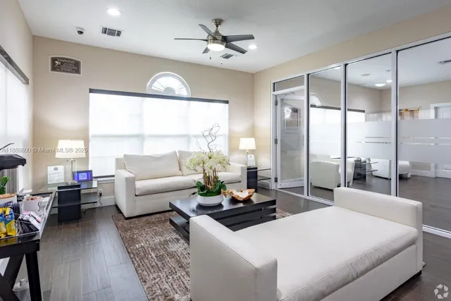 a living room with furniture a chandelier and a large window