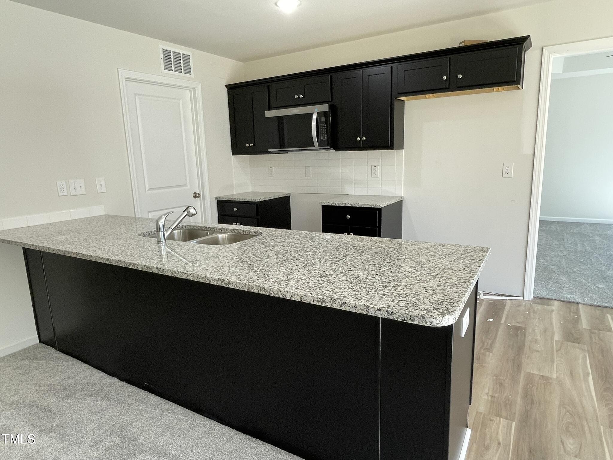 111 Magnolia Run Way Benson, NC 27504 - Photo 5 of 18 a kitchen with granite countertop a sink and a refrigerator