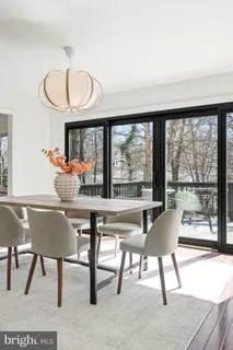a living room with a fireplace a flat screen tv and a floor to ceiling window