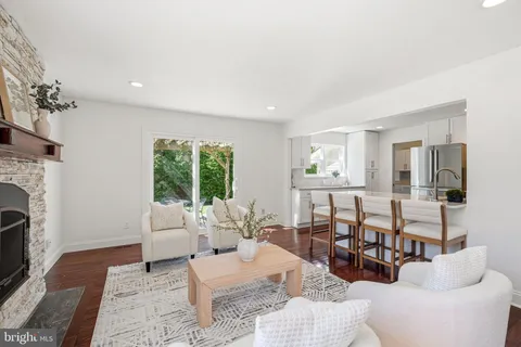 a kitchen with stainless steel appliances granite countertop a stove top oven a sink and white cabinets with wooden floor